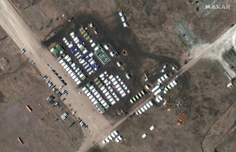 A satellite image shows a close-up of troops and equipment at Oktyabrskoye air base