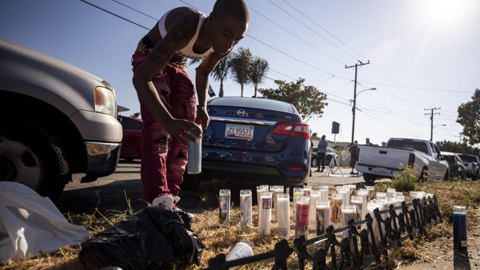 A person places a candle where Dijon Kizzee was shot