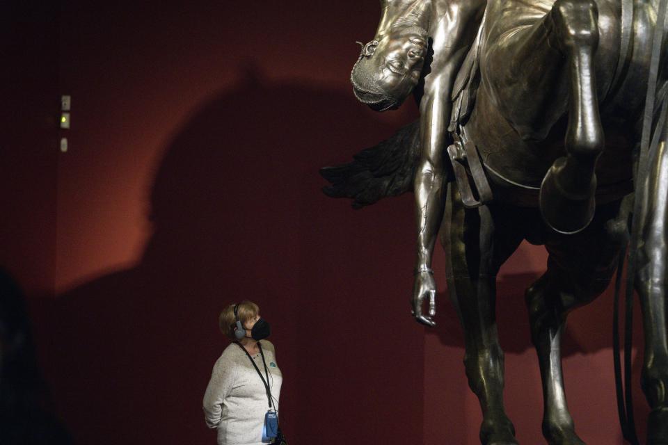 A woman looks at a bronze sculpture by Kehinde Wiley titled "An Archeology of Silence," at the de Young Museum in San Francisco, Friday, March 24, 2023. The sculpture is part of the "Kehinde Wiley: An Archaeology of Silence," exhibition. (AP Photo/Godofredo A. Vásquez)