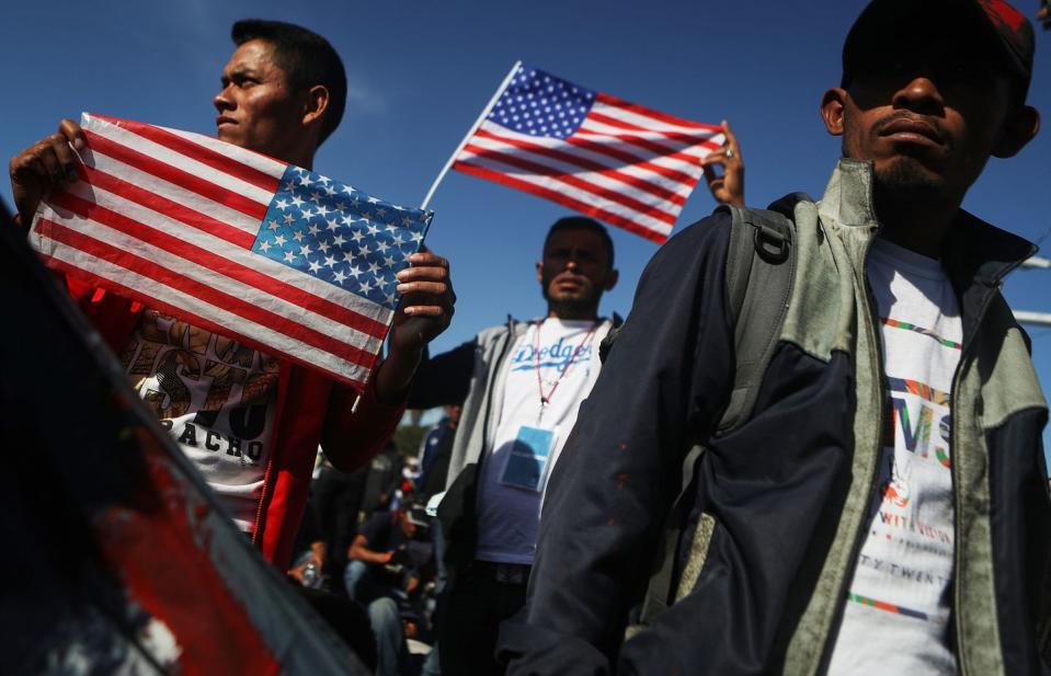 <p>Migrants hold American flags during a peaceful march shortly before some evaded a police blockade and rushed toward the El Chaparral port of entry on November 25, 2018 in Tijuana, Mexico.</p>