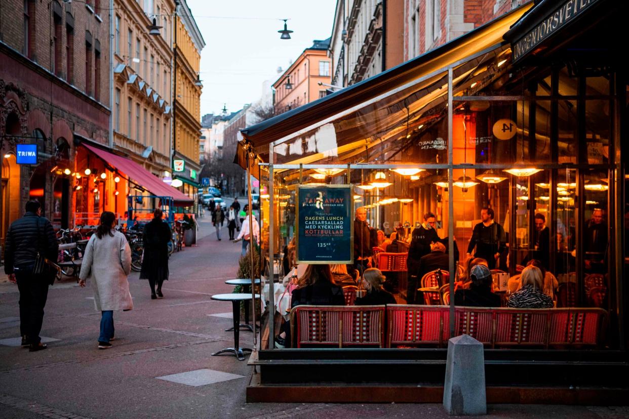 People dine in a restaurant in Stockholm: AFP via Getty Images
