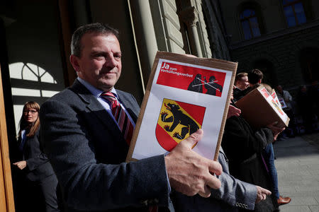 Walter Wobmann, National Councillor and Co-President committee for "Yes to a Mask Ban" (Ja zum Verhuellungsverbot), and members hand over boxes containing more than 100,000 signatures collected that are required to put the proposal of a ban on facial coverings worn by some Muslim women to a national vote, at the Federal Chancellery in Bern, Switzerland September 15, 2017. REUTERS/Moritz Hager