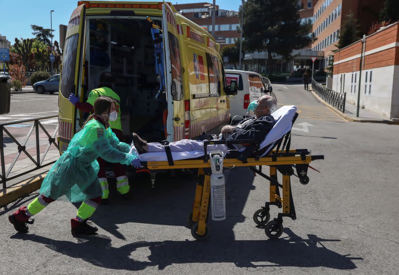 FOTO DE ARCHIVO: Un trabajador sanitario con una mascarilla facial y un traje protector transporta a un paciente de una ambulancia a la unidad de emergencia del hospital 12 de Octubre en Madrid