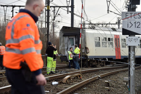 Rescuers and police officers stand next to the wreckage of a passenger train after it derailed in Kessel-Lo near Leuven, Belgium February 18, 2017. REUTERS/Eric Vidal
