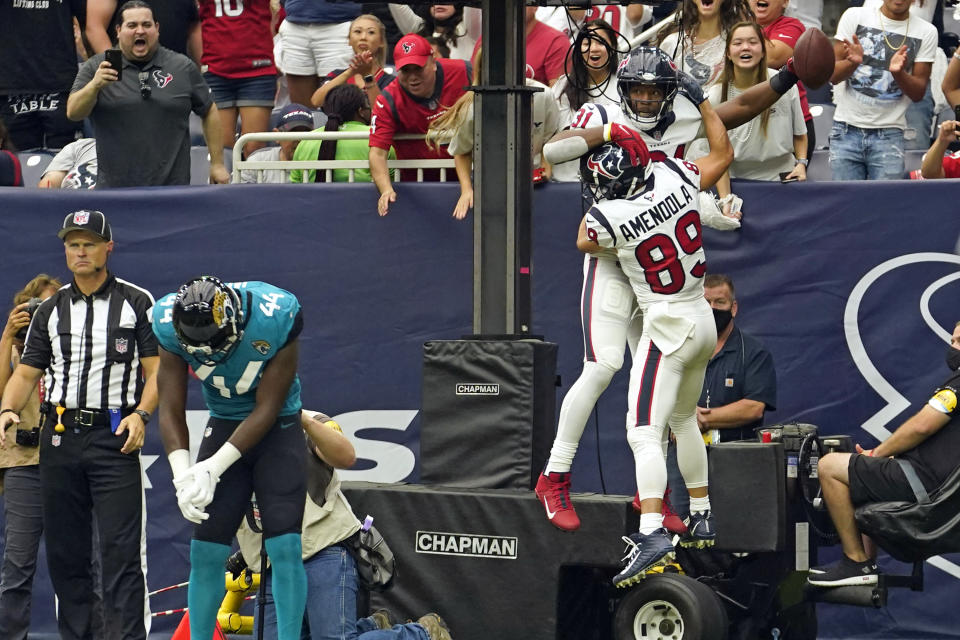 Houston Texans' David Johnson (31) celebrates his touchdown catch with Danny Amendola (89) as Jacksonville Jaguars linebacker Myles Jack (44) looks down at the goal line during the first half of an NFL football game Sunday, Sept. 12, 2021, in Houston. (AP Photo/Sam Craft)