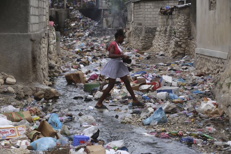 Una niña camina por una calle llena de basura en Puerto Príncipe, Haití, el jueves 13 de julio de 2023.