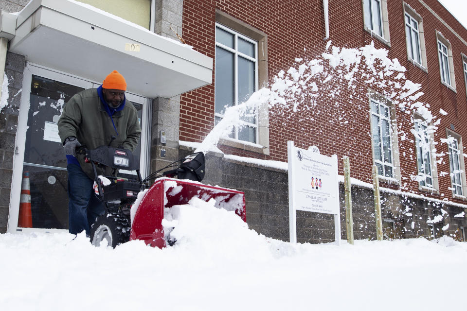 A man uses a snowblower to clear the sidewalk outside the Durham Memorial A.M.E Zion Church on Friday, Nov. 18, 2022, in Buffalo, N.Y. A dangerous lake-effect snowstorm paralyzed parts of western and northern New York, with nearly 2 feet of snow already on the ground in some places and possibly much more on the way. (AP Photo/Joshua Bessex)
