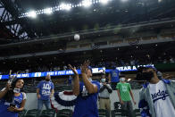 Los Angeles Dodgers fans try to catch a ball during batting practice before Game 5 of the baseball World Series against the Tampa Bay Rays Sunday, Oct. 25, 2020, in Arlington, Texas. (AP Photo/Eric Gay)