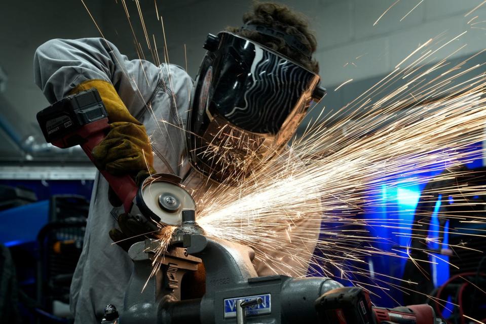 Parker Slaugenhaupt of Chariho High School sends sparks flying as he grinds down the metal parts of his submarine during Monday's welding competition at Providence Career & Technical Academy. The event was aimed at getting students interested in careers in shipbuilding trades.
