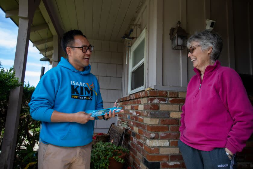Van Nuy, CA - March 31: Issac Kim, left, is a candidate for the City Council District 6 race on Friday, March 31, 2023, in Van Nuy, CA. He is speaking with Karen Shaw as he campaigns door to door. (Francine Orr / Los Angeles Times)