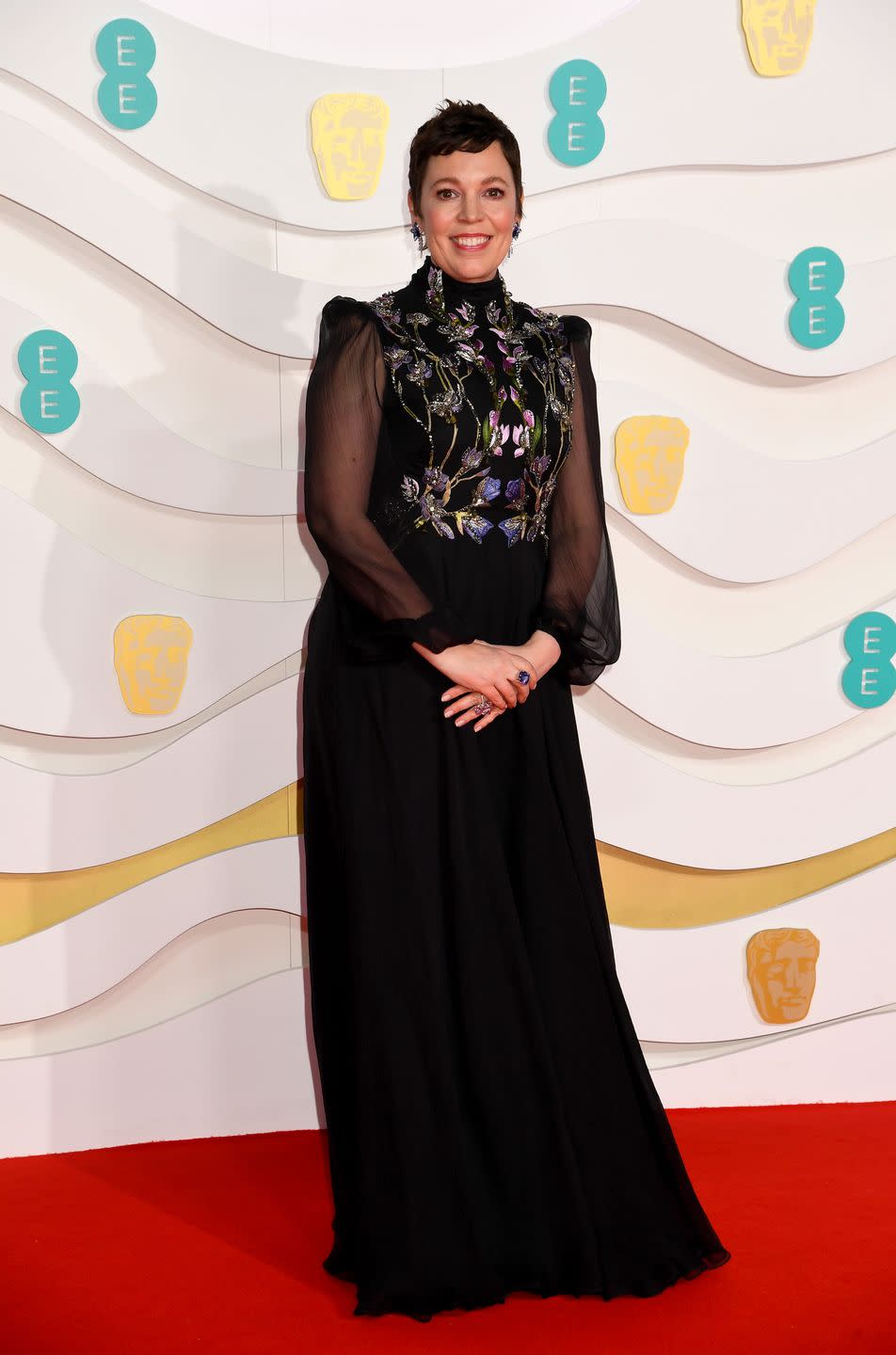 <p>Olivia Colman proved it's all in the details in this sheer-sleeved, embroidered Alexander McQueen gown which she paired with Swarovski earrings. </p>