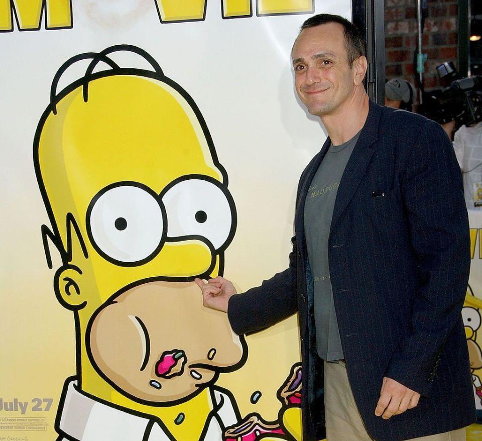 Hank Azaria junto a un poster de los Simpons.