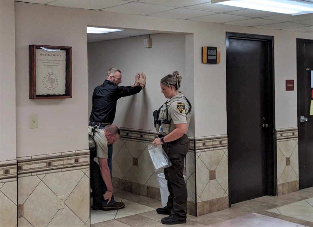 Clinton Thompson is patted down by deputies outside a Wichita County courtroom Thursday. He pleaded guilty to manslaughter and aggravated assault.