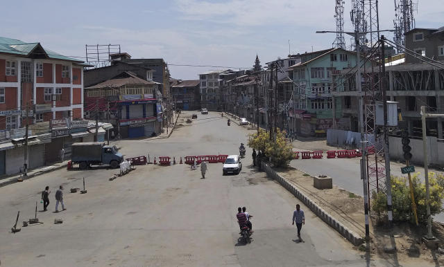 Pedestrians move on a deserted street in Srinagar, Indian controlled Kashmir, Thursday, Aug. 8, 2019. The lives of millions in India's only Muslim-majority region have been upended since the latest, and most serious, crackdown followed a decision by New Delhi to revoke the special status of Jammu and Kashmir and downgrade the Himalayan region from statehood to a territory. Kashmir is claimed in full by both India and Pakistan, and rebels have been fighting Indian rule in the portion it administers for decades. (AP Photo/Sheikh Saaliq)