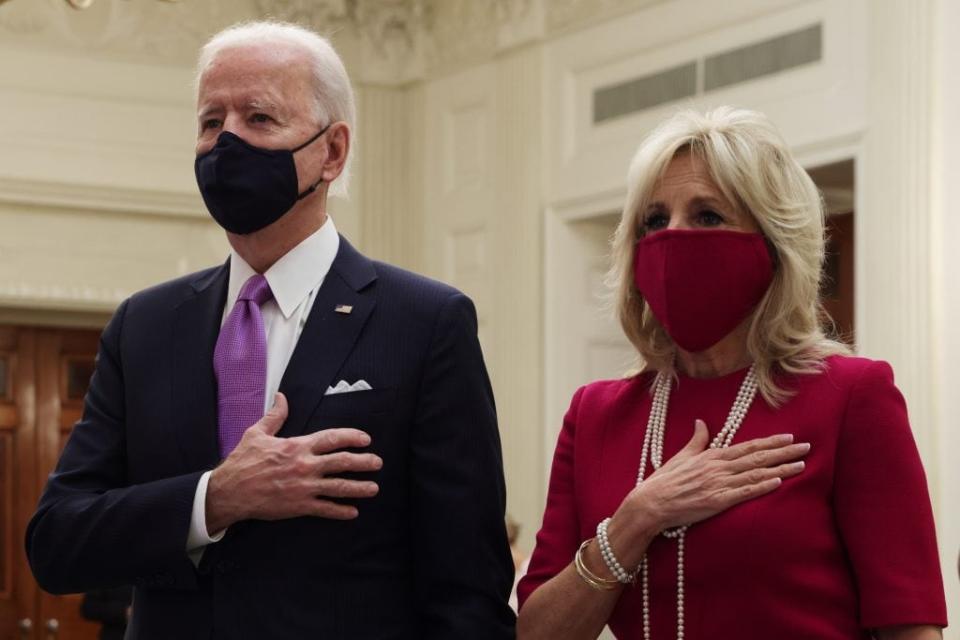 U.S. President Joe Biden (L) and first lady Dr. Jill Biden listen to the national anthem as they watch the virtual presidential inaugural prayer service in the State Dining Room of the White House January 21, 2021 in Washington, DC. (Photo by Alex Wong/Getty Images)
