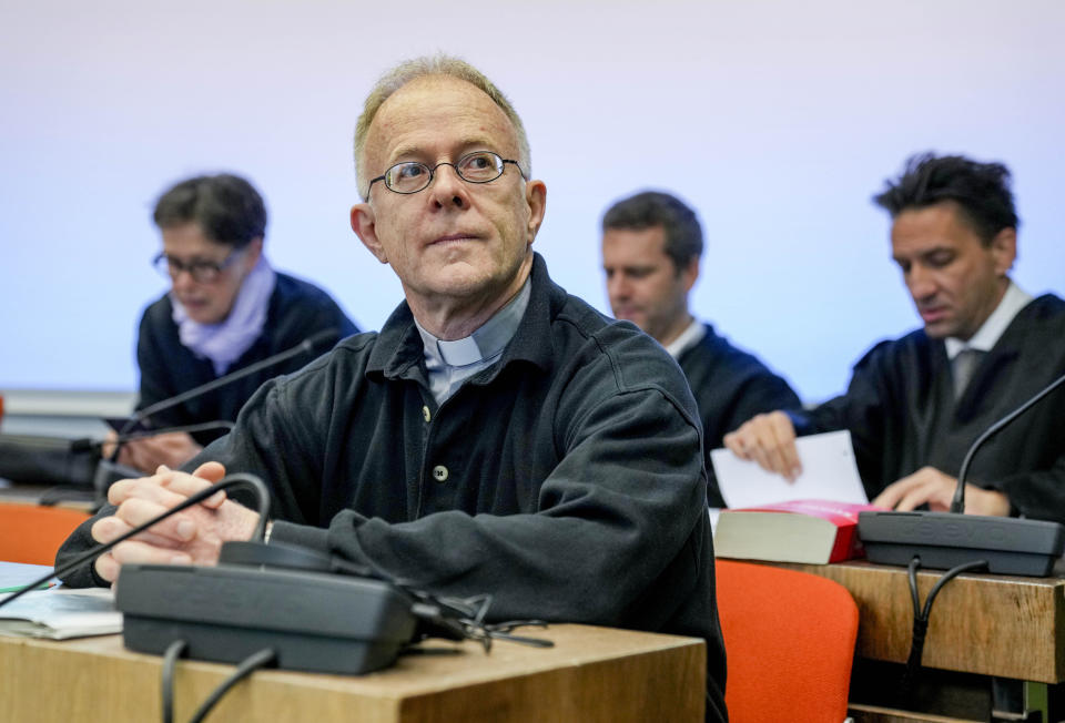 FILE - Priest Joerg Alt, front, attends the beginning of his trial at a court in Munich, Germany, Wednesday, May 3, 2023. A German court on Tuesday convicted a Jesuit priest of coercion in connection with a climate protest last year and ordered him to pay a small fine. In Alt's case, that was a 10-euro ($10.85) fine. (AP Photo/Matthias Schrader, File)