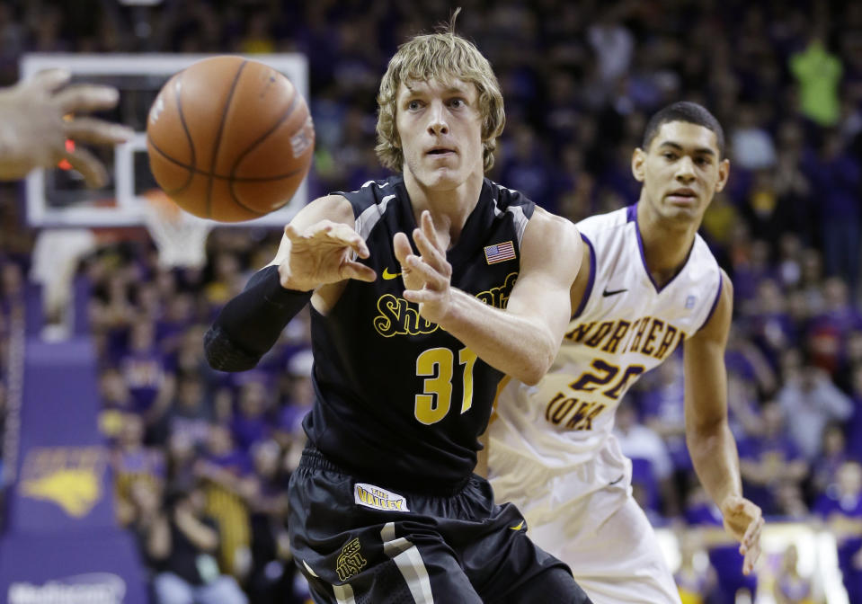 Wichita State guard Ron Baker, left, passes in front of Northern Iowa guard Jeremy Morgan during the first half of an NCAA college basketball game on Saturday, Feb. 8, 2014, in Cedar Falls, Iowa. (AP Photo/Charlie Neibergall)