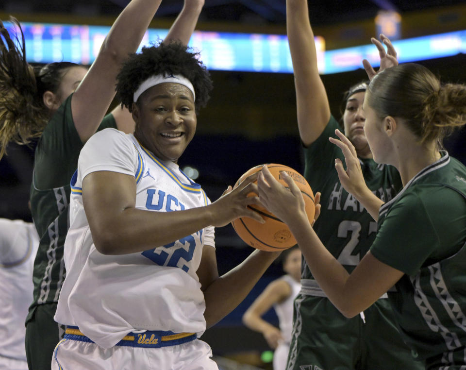 UCLA forward Christeen Iwuala, front left, grabs a rebound in front Hawaii center Brooklyn Rewers, back left, guard MeiLani McBee, second from right, and guard Ashley Thoms, right, during the first half of an NCAA college basketball game Thursday, Dec. 21, 2023, in Los Angeles. (AP Photo/Jayne Kamin-Oncea)