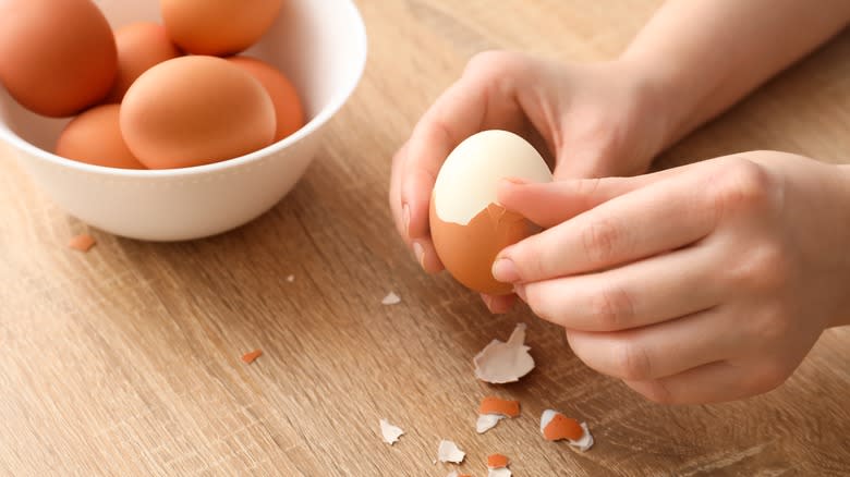 hands peeling egg