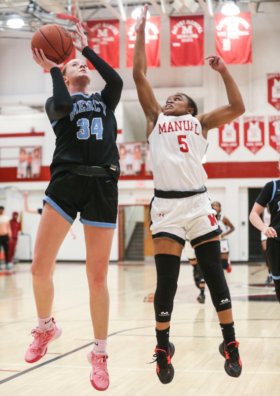 Mercy's Emma Barnett goes for two as DuPont Manual's Sydne Tolbert guards in the Crimsons' win Tuesday night at DuPont Manual High School. Dec. 6, 2022
