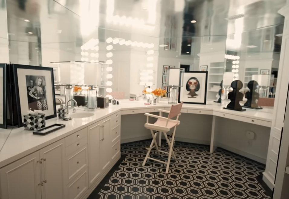 the glam room in RuPaul's home, with a makeup chair, mirrored walls, and tile floor