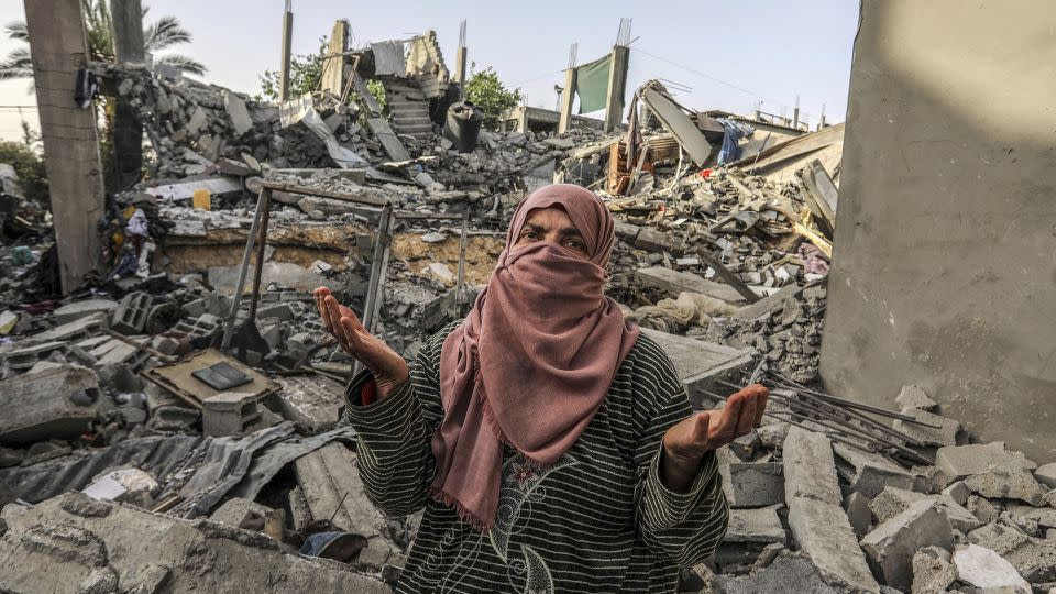 A Palestinian woman inspects a house that was destroyed by Israeli bombing in Rafah, in the south of the Gaza Strip, on Wednesday. - Abed Rahim Khatib/picture-alliance/dpa/AP