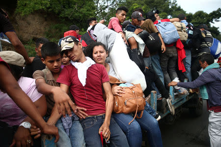 Honduran migrants, part of a caravan trying to reach the U.S., are pictured on a truck during a new leg of their travel in Zacapa, Guatemala October 17, 2018. REUTERS/Edgard Garrido