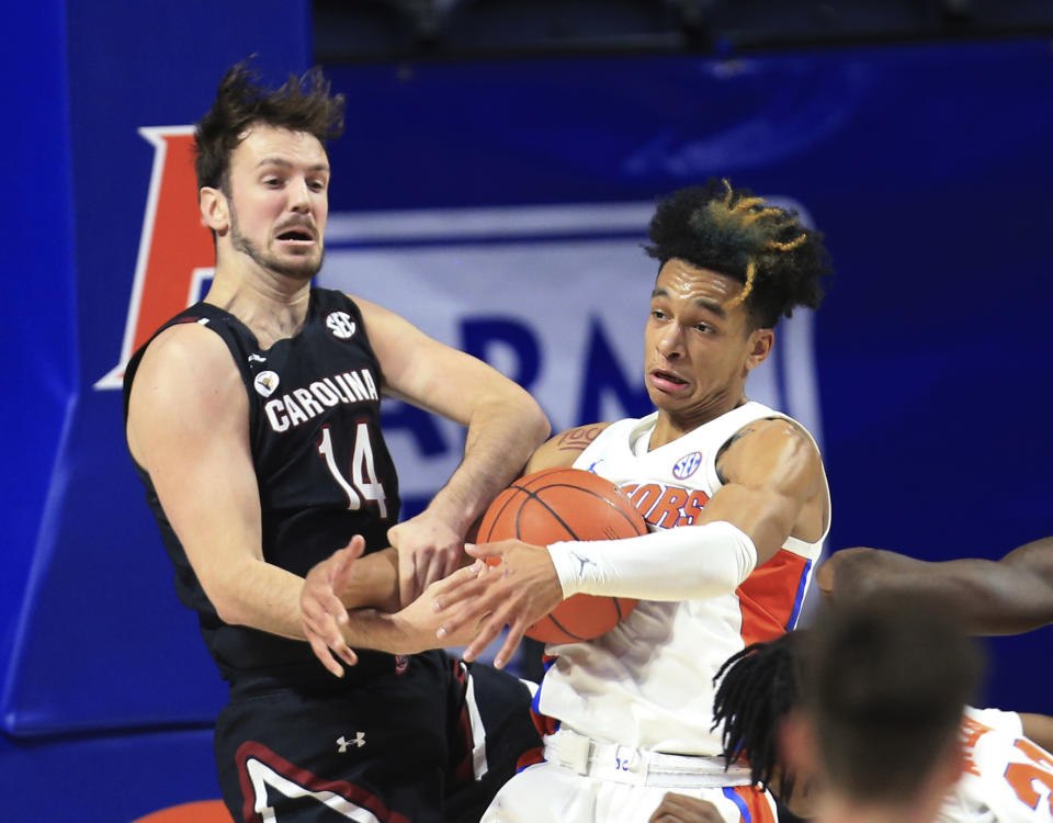 Florida guard Tre Mann, right,and South Carolina forward Nathan Nelson (14) struggle for a rebound during the first half of an NCAA college basketball game Wednesday, Feb. 3, 2021, in Gainesville, Fla. (AP Photo/Matt Stamey)