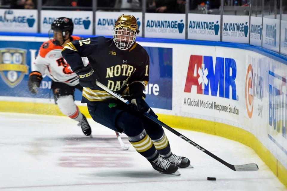 Notre Dame defenseman Henry Nelson (12) skates with the puck during the second period of an NCAA hockey game against RIT on Saturday, Oct.14, 2023 in Rochester, N.Y. (AP Photo/Adrian Kraus)