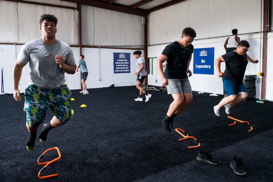 From left, York High football players Jayden Watson, Elijah Rolle and Roberto Vazquez Montanez use agility hurdles to complete a plyometric training exercise at Accountability For Life's new facility on Tuesday, May 3, 2022, in York.