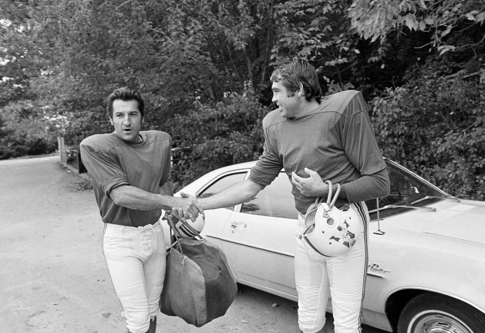 FILE -Joe Kapp, right, shakes hands with Gino Cappelletti at Curry College in Milton, Mass., Oct. 2, 1970, before Boston Patriots workout session. Gino Cappelletti, a former AFL Most Valuable Player and original member of the Boston Patriots who was part of the franchise for five decades as a player, coach and broadcaster, has died. He was 89. Cappelletti died at his home in Wellesley, Massachusetts. His death was announced by the New England Patriots on Thursday, May 12, 2022. No cause of death was given. (AP Photo/A.E. Maloof, File)