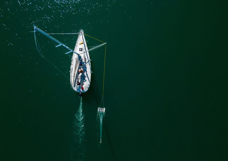 Un barco de la ONG Oceaneye recoge fragmentos de plástico en el agua del lago Leman