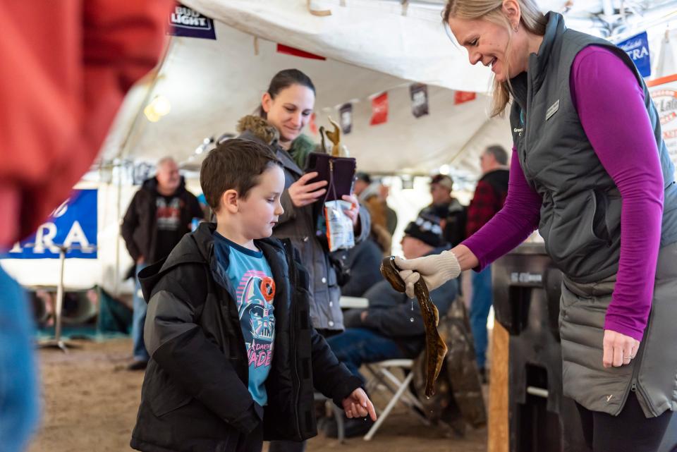 Andrea Miehls, communications associate with the Great Lakes Fishery Commission, shows a sea lamprey to Logan Fletcher at the Black Lake Sturgeon Shivaree on Saturday, Feb. 3, 2024.