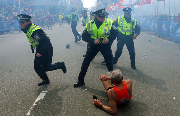 Bill Iffrig, 78, lies on the ground as police officers react to a second explosion at the finish line of the Boston Marathon. Photo: AP