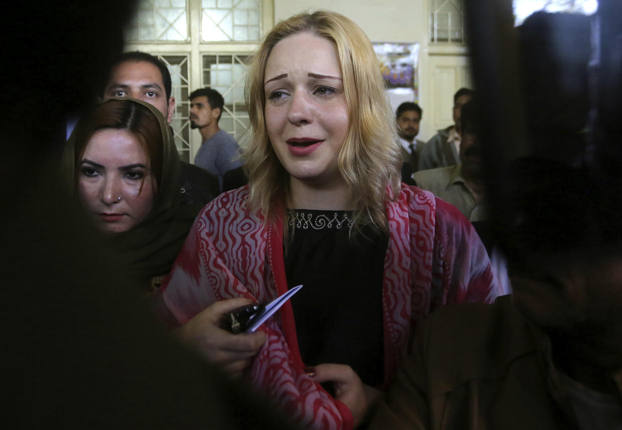 FILE - Czech model Tereza Hluskova, center, reacts after appearing in court in Lahore, Pakistan on March 20, 2019. Hluskova, who was sentenced to eight years on charges of attempting to smuggle heroin from Pakistan to Abu Dhabi will be freed next week following her acquittal by an appeal court, a defense lawyer said Friday, Nov. 5, 2021. (AP Photo/K.M. Chaudary, File)