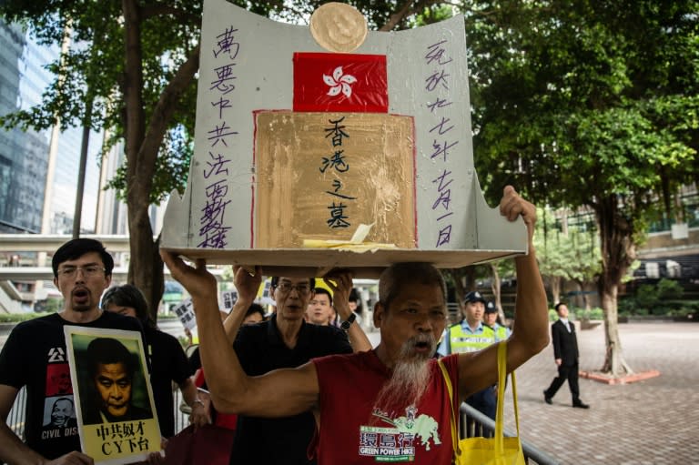 Political activist Koo Sze-yiu holds a cardboard coffin with a an epitaph that reads "Grave of Hong Kong - Date of Death: 1997" during a rally in Hong Kong on July 1, 2015, on the anniversary of Hong Kong's handover to China