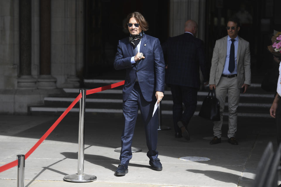 Actor Johnny Depp, centre, arrives at the High Court for a hearing in his libel case, in London, Friday, July 24, 2020. Depp is suing News Group Newspapers, publisher of The Sun, and the paper's executive editor, Dan Wootton, over an April 2018 article that called him a "wife-beater." The Sun's defense relies on a total of 14 allegations by his ex-wife, actress Amber Heard of Depp's violence. He strongly denies all of them. (Kirsty O'Connor/PA via AP)