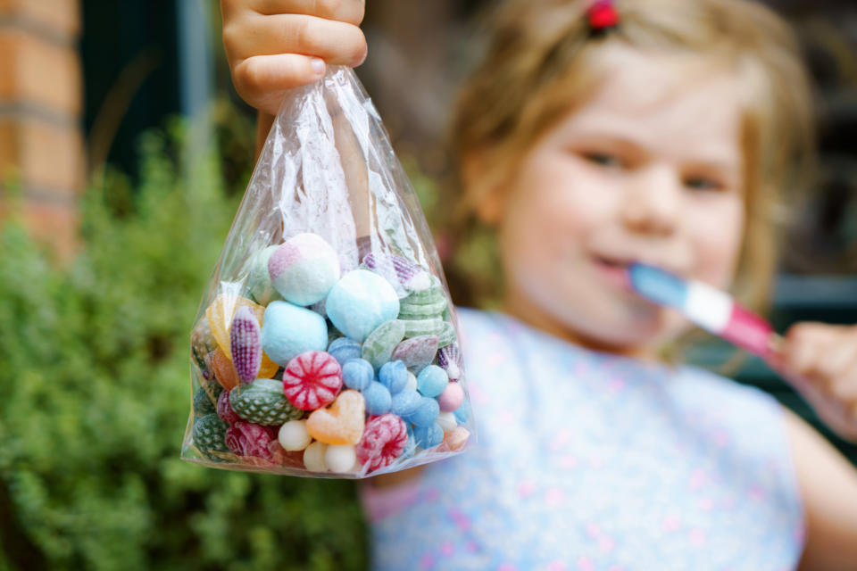 Child holding a bag of loose candies