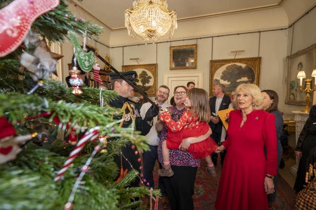 The Queen Consort, accompanied by children supported by Helen and Douglas House and Roald Dahl’s Marvellous Children’s Charity, decorate the Christmas tree at Clarence House in London