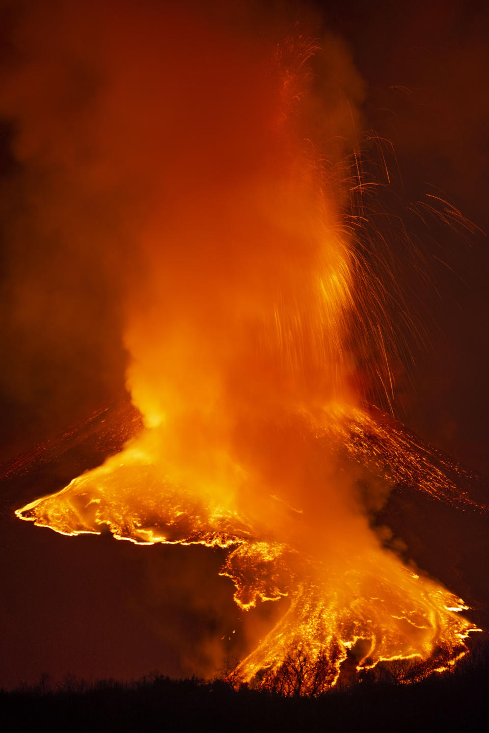 A fiery river of glowing lava flows on the north-east side of the Mt Etna volcano near Milo, Sicily, Wednesday night, Feb. 24, 2021. Europe's most active volcano has been steadily erupting since last week, belching smoke, ash, and fountains of red-hot lava. (AP Photo/Salvatore Allegra)