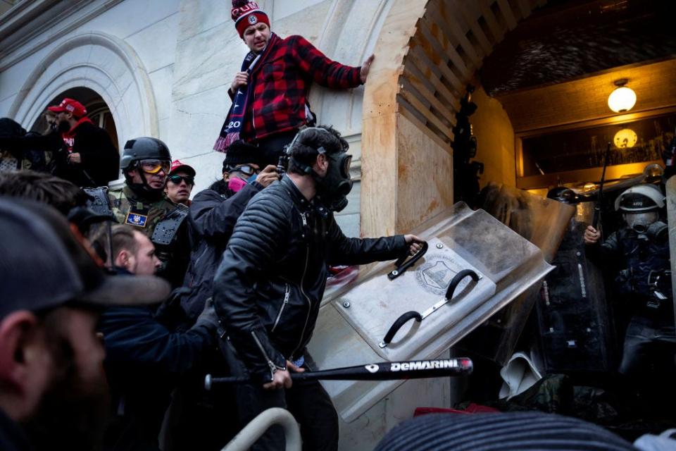 FBI have identified Edward Lang as the man with the shield and baseball bat in this photo from Jan. 6, in which a pro-Trump mob clashes with police and security forces as people try to storm the US Capitol.
