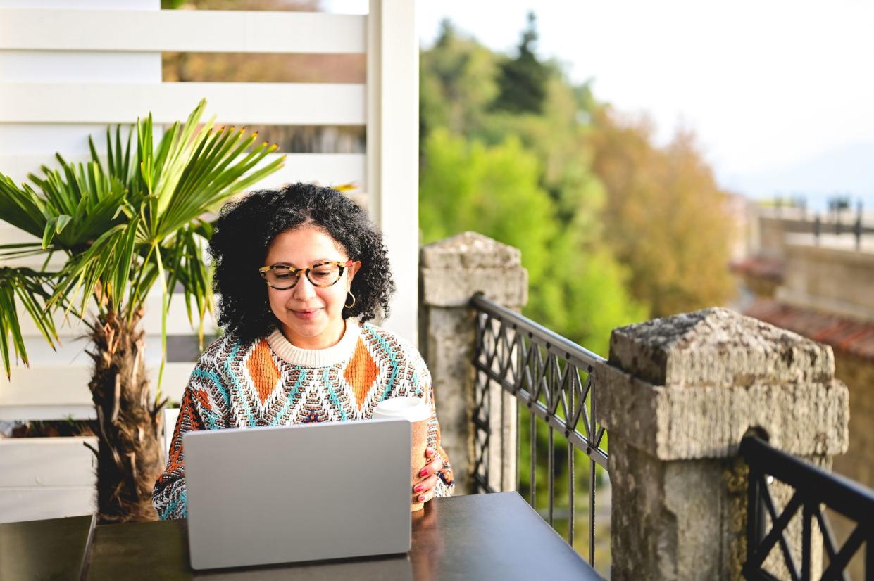 front view of a multiracial female working on computer on a sunny day remotly.