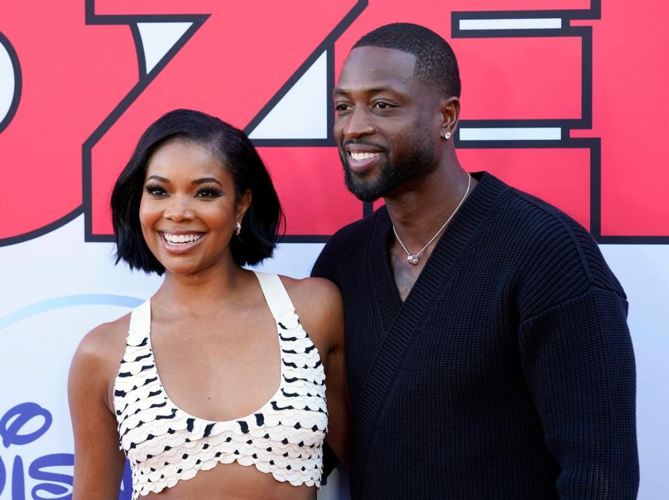 Gabrielle Union and Dwyane Wade smile and pose together at a movie premiere in 2022.