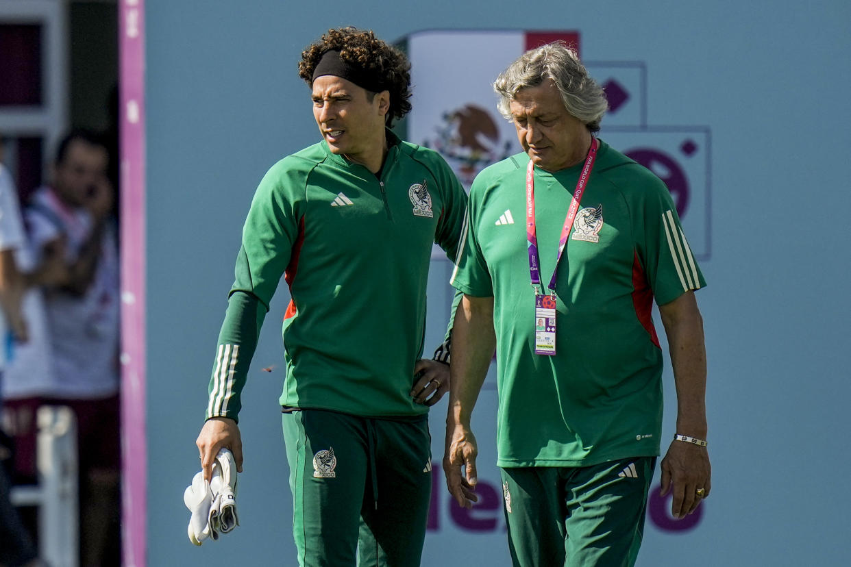 Goalkeeper Guillermo Ochoa, left, and assistant coach Norberto Scoponi talk during Mexico official training on the eve of the group C World Cup soccer match between Saudi Arabia and Mexico, in Jor, Qatar, Tuesday, Nov. 29, 2022. (AP Photo/Moises Castillo)