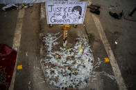Melted candles are seen next to a placard at a demonstration site outside a crematorium where a 9-year-old girl from the lowest rung of India's caste system was, according to her parents and protesters, raped and killed earlier this week, in New Delhi, India, Thursday, Aug. 5, 2021. (AP Photo/Altaf Qadri)