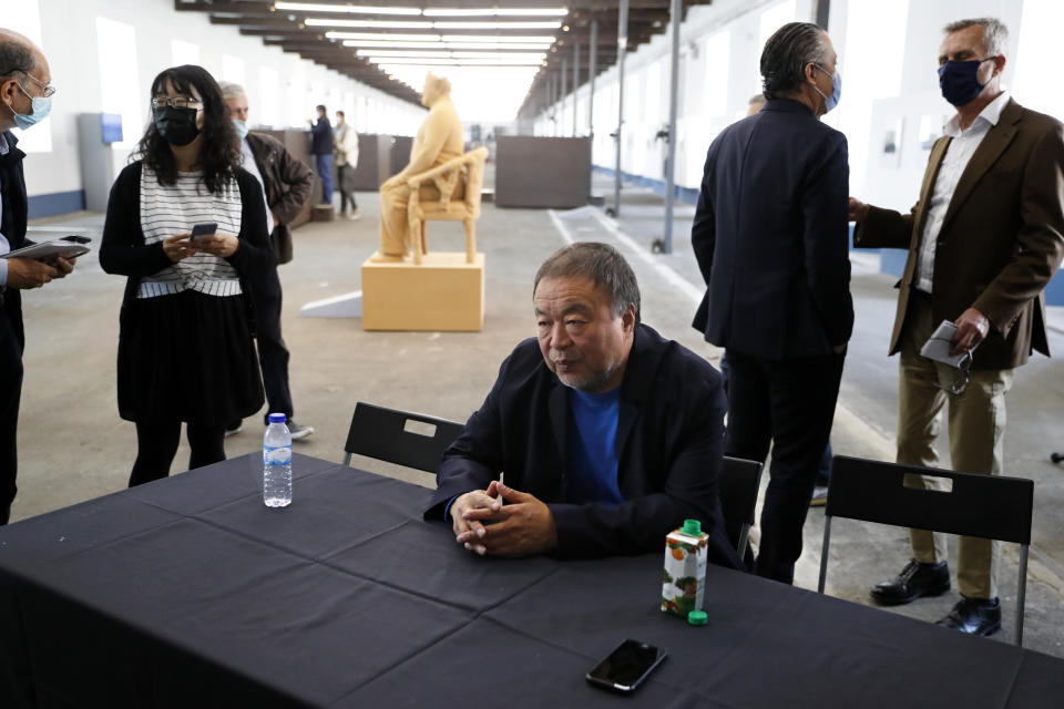 Dissident Chinese artist Ai Weiwei sits at a table at the end of a news conference during a press preview of his new exhibition "Rapture" in Lisbon, Thursday, June 3, 2021. The world-renowned artist is putting on the biggest show of his career, and he is doing it in a place he's fallen in love with: Portugal. (AP Photo/Armando Franca)