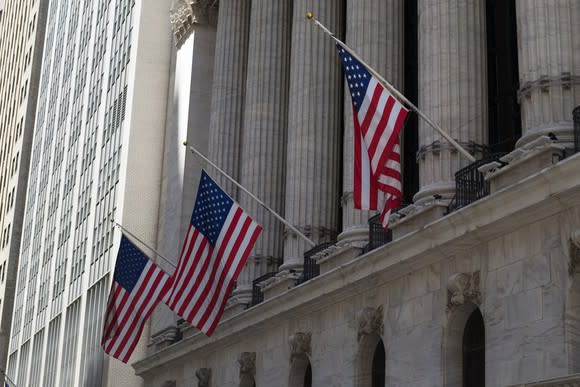 Front of New York Stock Exchange, with three U.S. flags hanging.