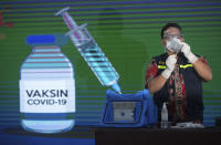 A health worker prepares to give the COVID-19 vaccine to a government official in Medan, North Sumatra, Indonesia, Thursday, Jan. 14, 2021. Indonesia started vaccinating health workers and public servants against COVID-19 on Thursday, a day after President Joko Widodo received the first shot of China's Sinovac Biotech vaccine. The Health Ministry is planning to vaccinate more than 1.3 millions health workers and 17.4 millions public officers in the first stage in the world's fourth most populated country. (AP Photo/Binsar Bakkara)