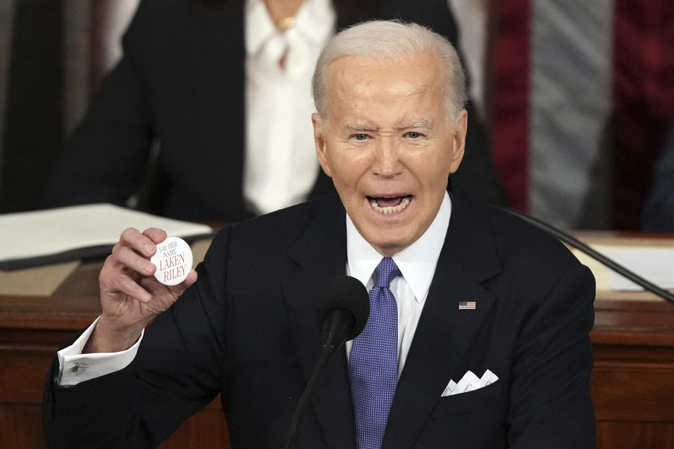 President Joe Biden holds up a Laken Riley Botton as he delivers the State of the Union address to a joint session of Congress at the U.S. Capitol, Thursday March 7, 2024, in Washington. (AP Photo/Andrew Harnik)