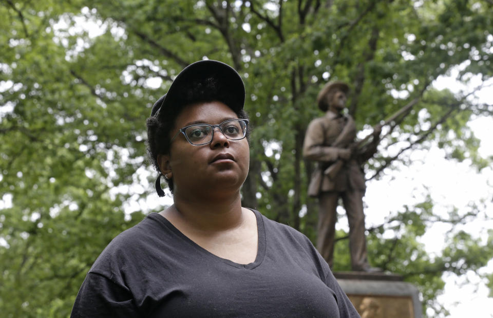 FILE - In this May 15, 2018, file photo, activist Maya Little is photographed as she takes an interview near the Silent Sam Confederate statue on campus at the University of North Carolina in Chapel Hill, N.C. Little, a UNC-Chapel Hill graduate student at the forefront of protests over a Confederate statue on campus, has been arrested again. News outlets report authorities say 26-year-old Maya Little is charged with inciting a riot and assaulting an officer during a rally Monday, Dec. 3. (AP Photo/Gerry Broome, File)